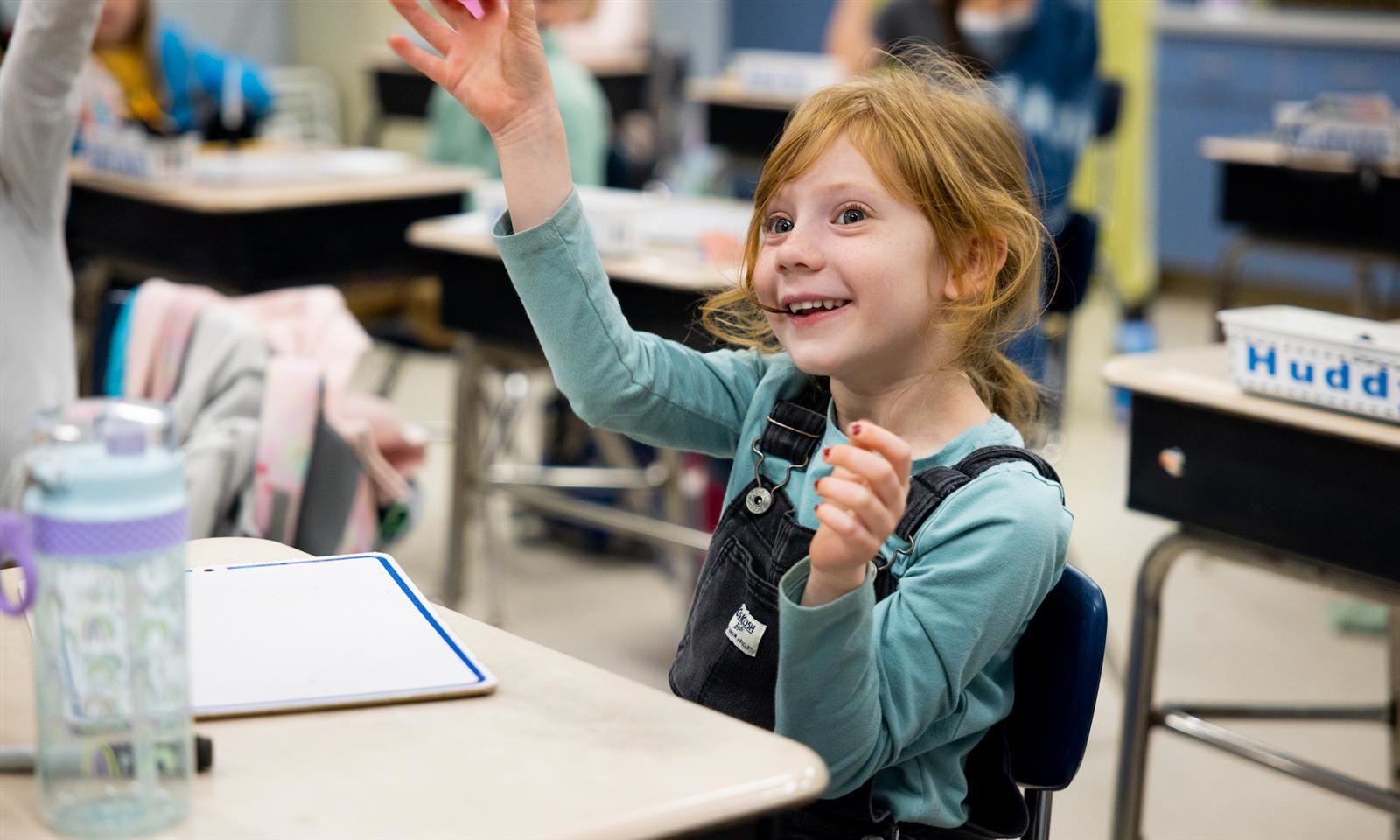 a girl raises her hand